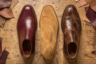 Comparaison de trois types de cuir pour chaussures : cuir lisse, nubuck et cuir gras côte à côte sur bois brut
